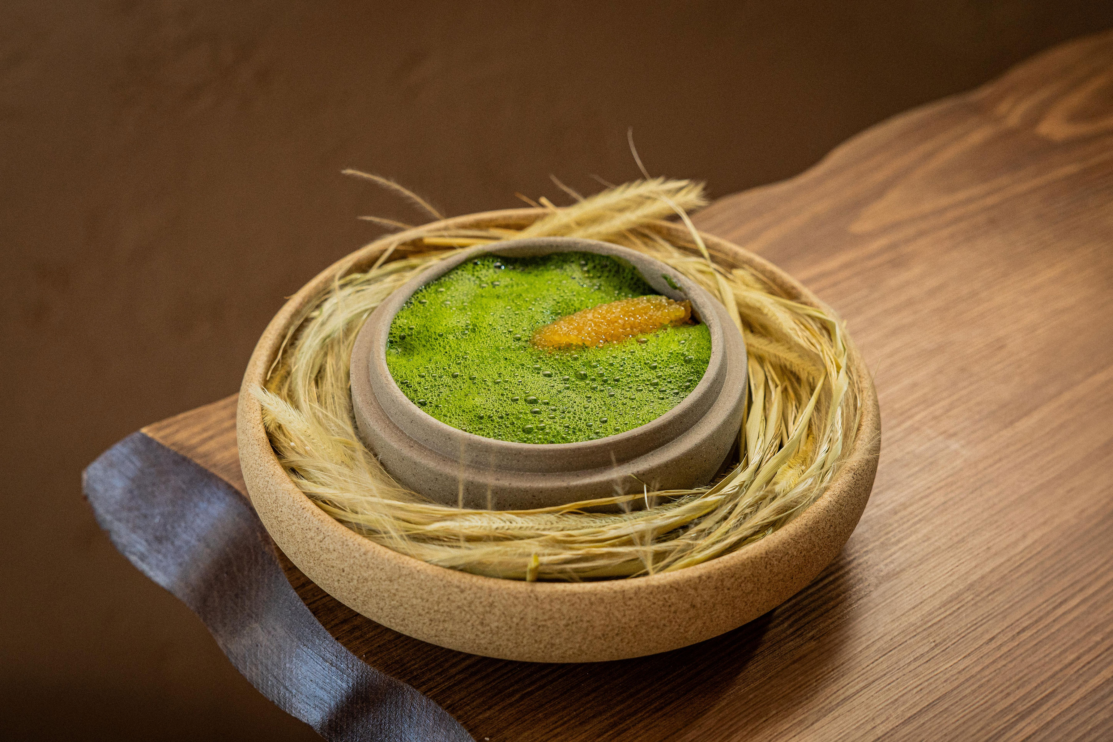 Smoked potato with hay-infused cream in a bowl.